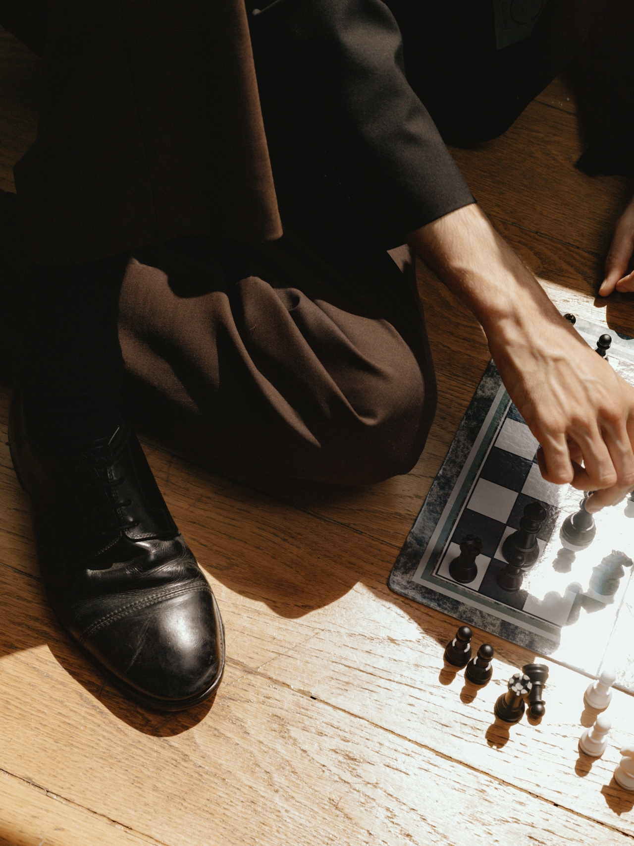 Person i kostym som spelar schack på golvet